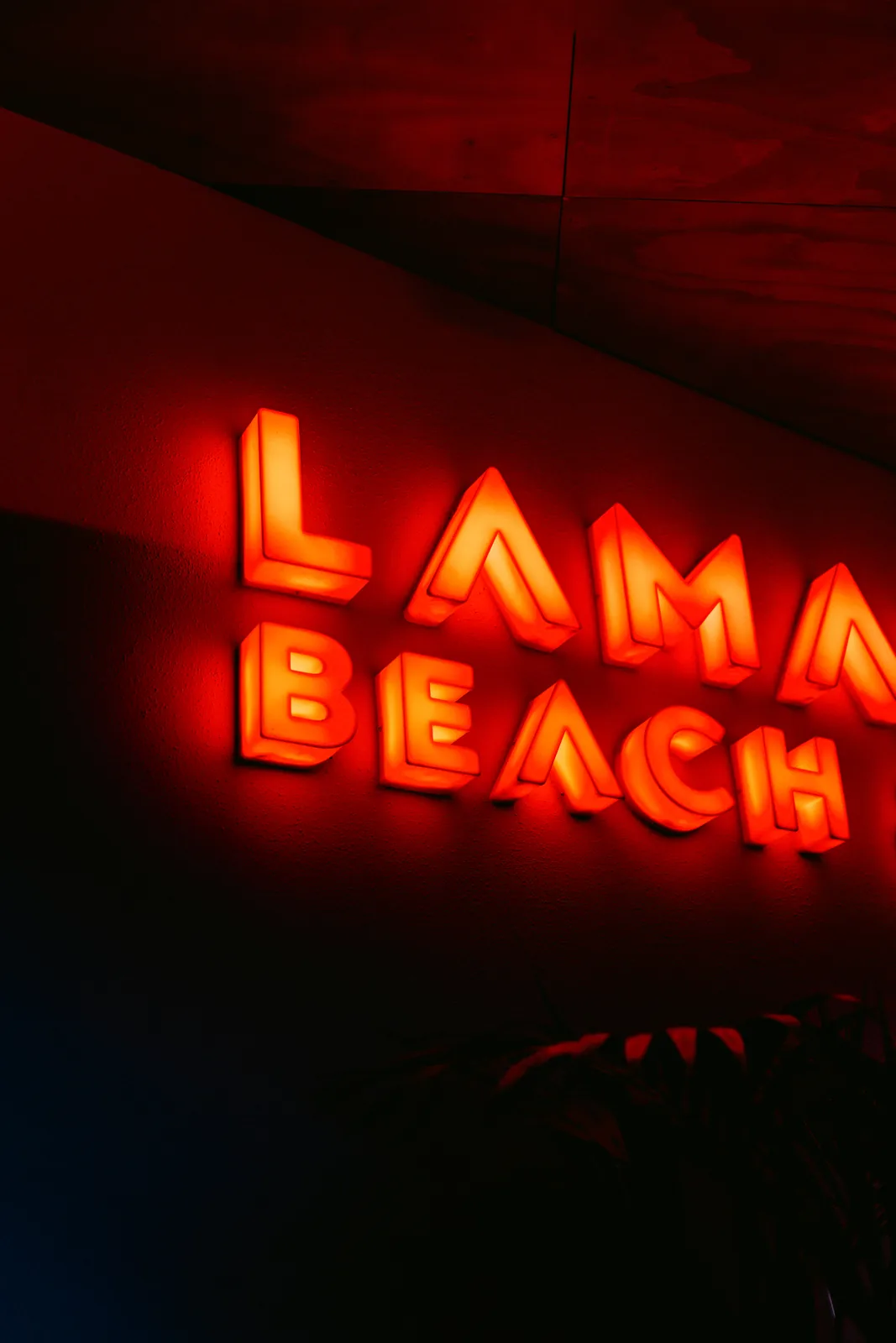 Rótulo de neón de LaMalaka Beach encendido de noche.